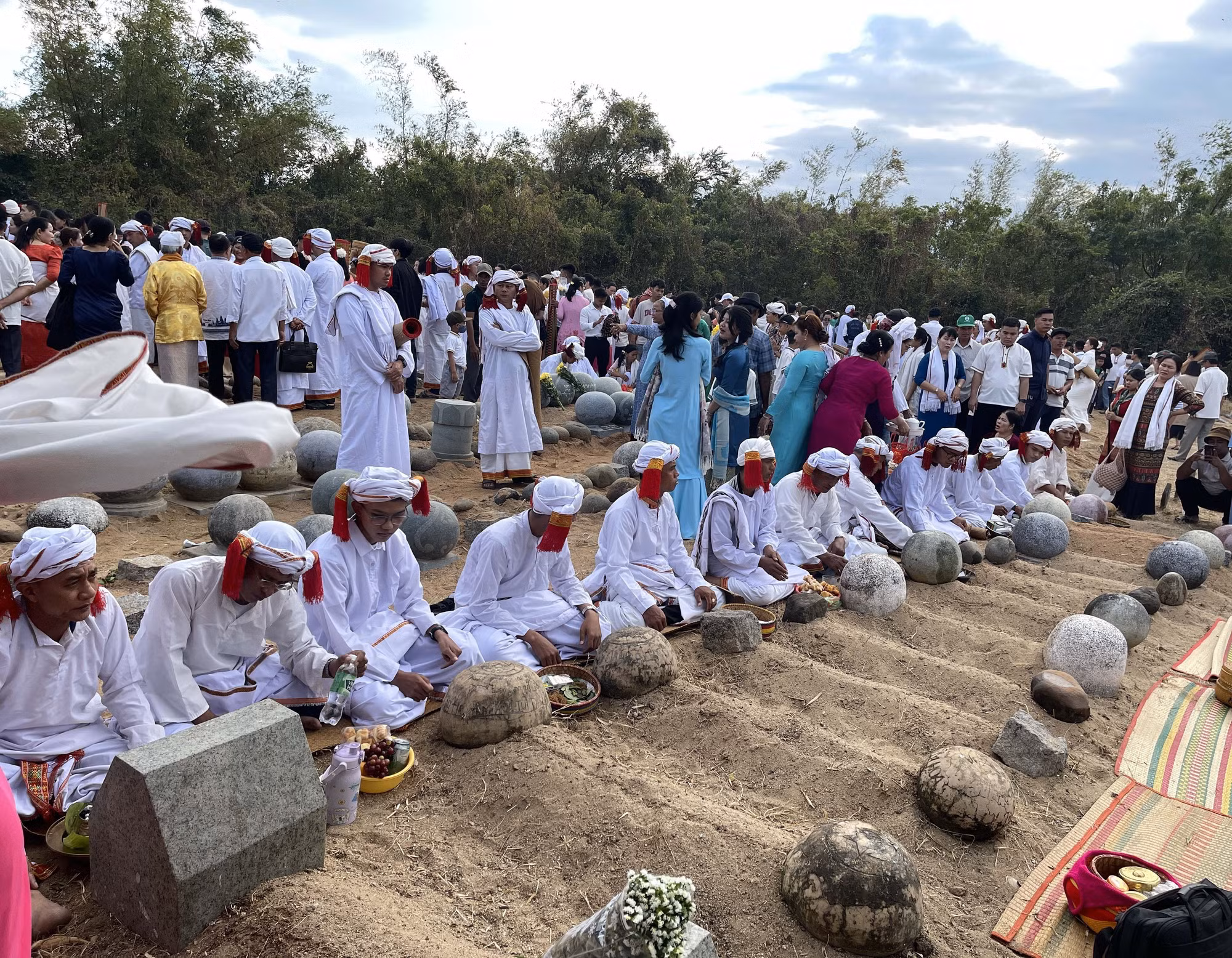 Con, cháu dòng tộc theo đạo Hồi giáo Bàni mặc bộ áo truyền thống thực hiện nghi lễ tảo mộ tại nghĩa trang, mời tổ tiên về chung vui Tết Ramưvan.