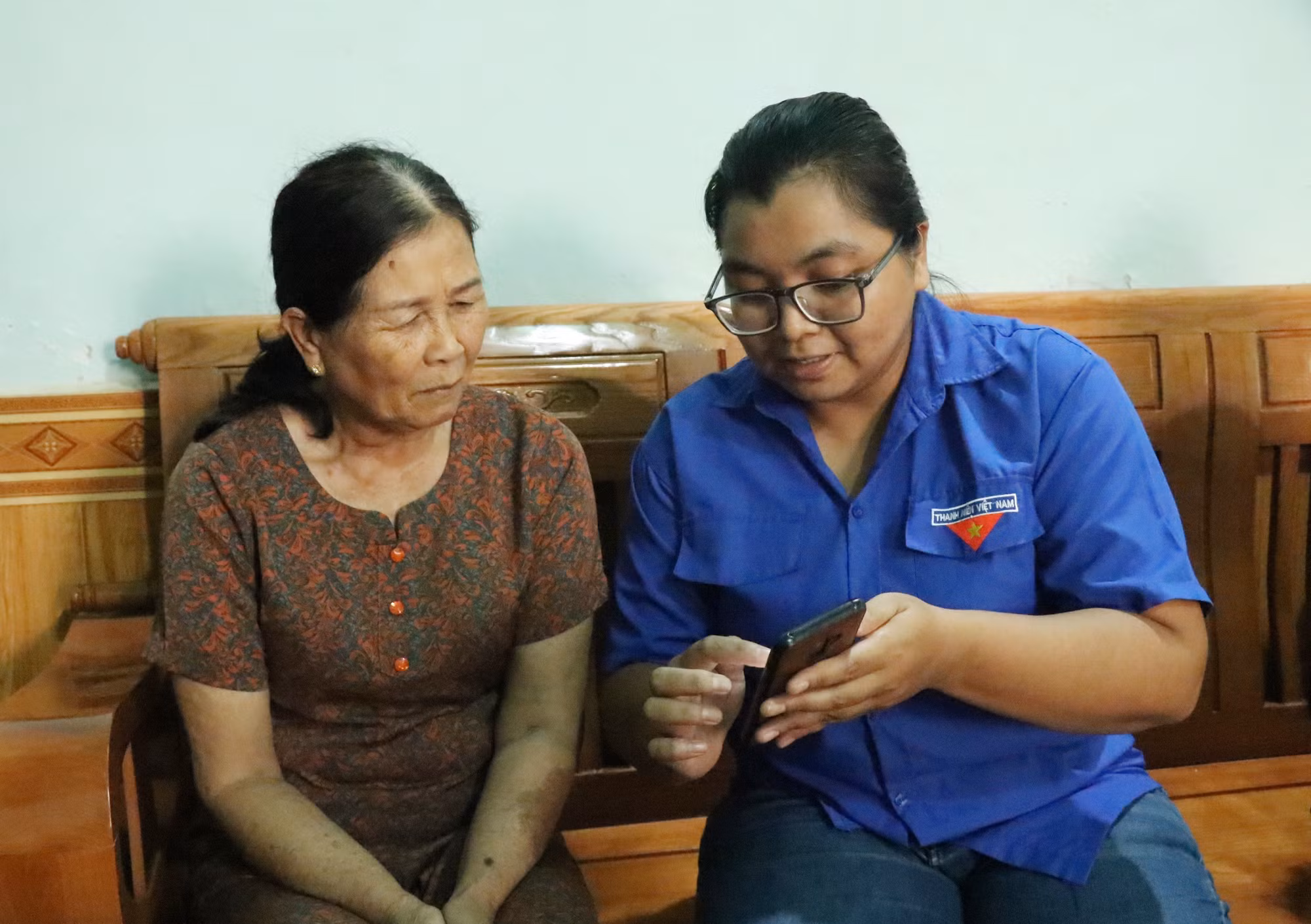 Thành viên Tổ công nghệ số cộng đồng Buôn Alê B, phường Ea Kao, tỉnh Đắk Lắk hướng dẫn người dân sử dụng các ứng dụng để làm thủ tục hành chính.