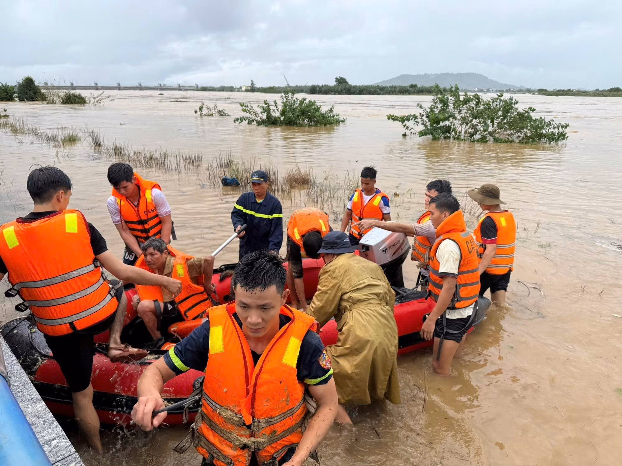 Lực lượng Cảnh sát phòng cháy chữa cháy Công an tỉnh Quảng Ngãi cưỡng chế đưa người dân giữa dòng sông Trà Khúc vào bờ. Ảnh: TTXVN