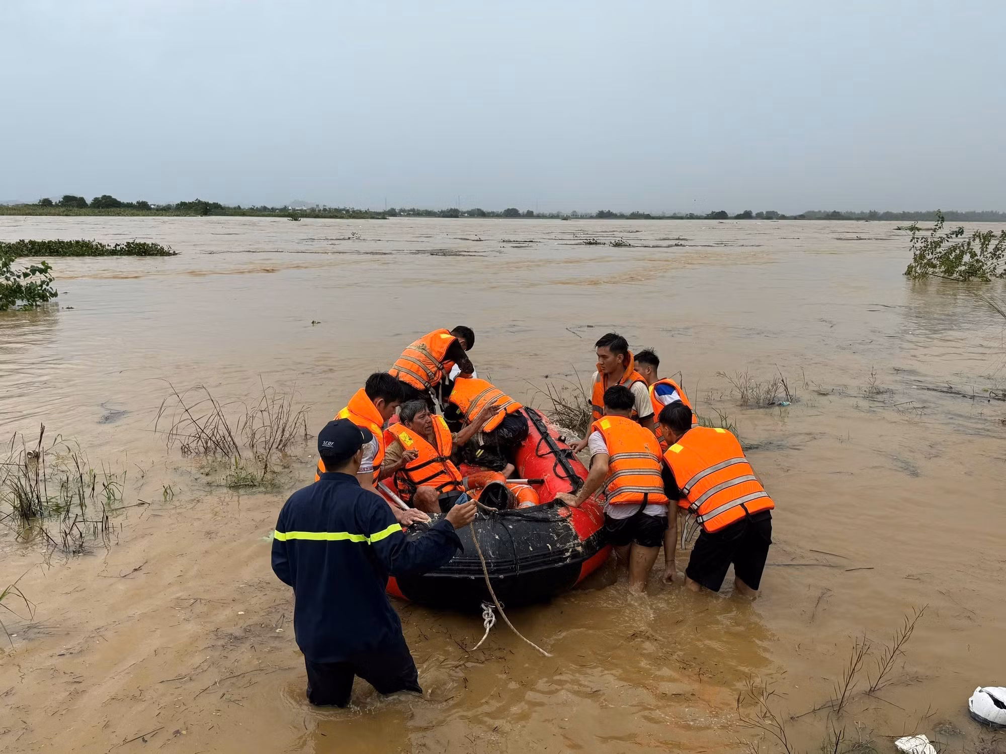 Lực lượng Cảnh sát phòng cháy chữa cháy Công an tỉnh Quảng Ngãi cưỡng chế đưa người dân giữa dòng sông Trà Khúc vào bờ. Ảnh: TTXVN