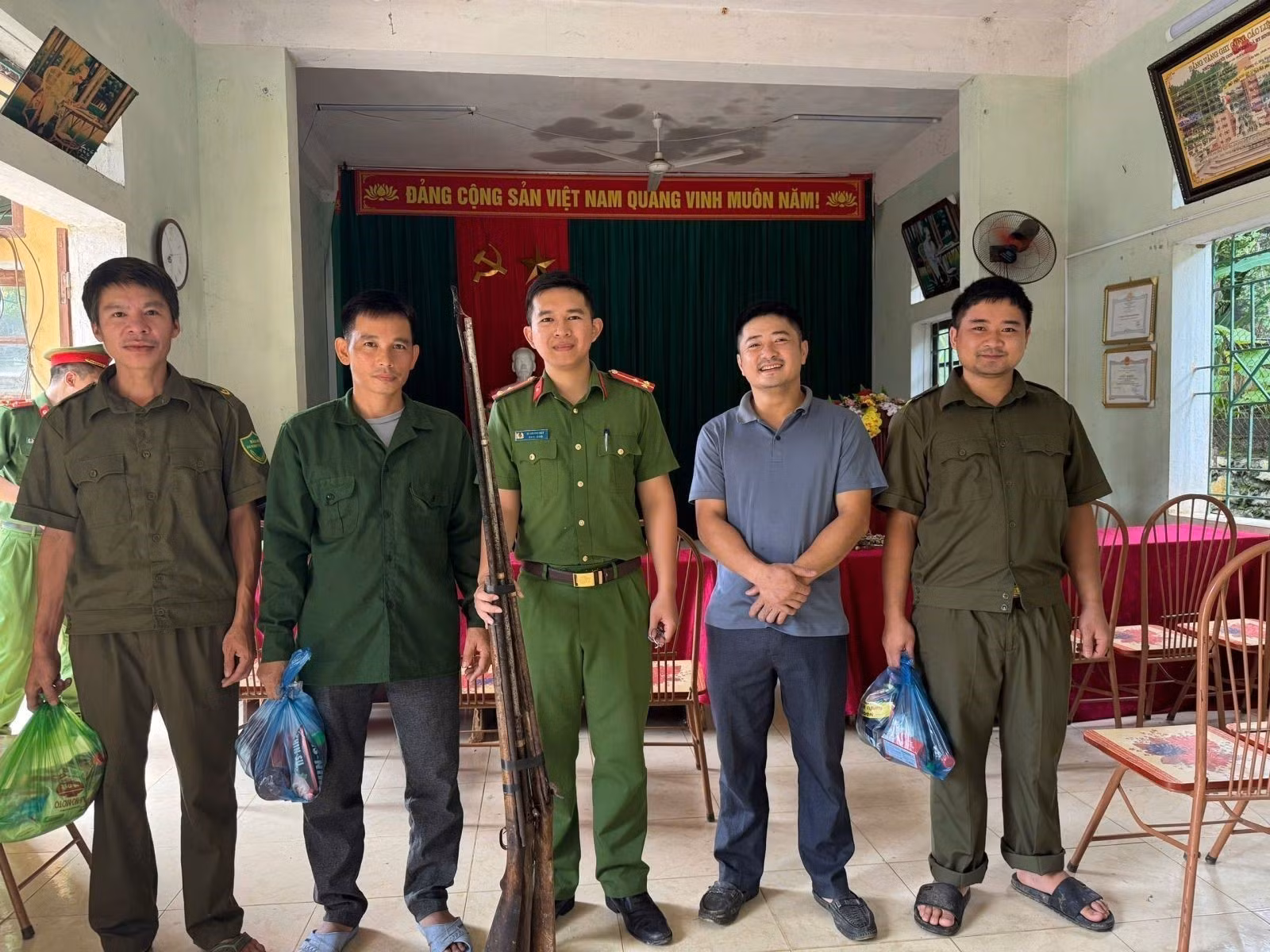 Người dân đem súng săn, súng tự chế giao nộp cho Công an xã Hồi Xuân để đổi lấy quà tặng. Ảnh: TTXVN phát