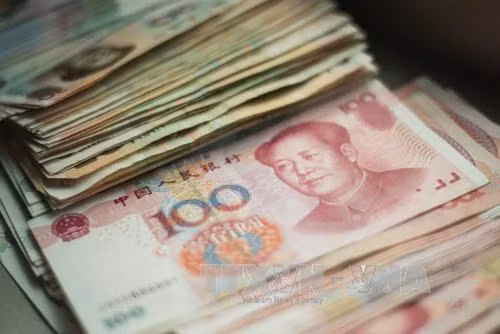 Đồng tiền mệnh giá 100 NDT tại Bắc Kinh, Trung Quốc. Ảnh: AFP/TTXVN
