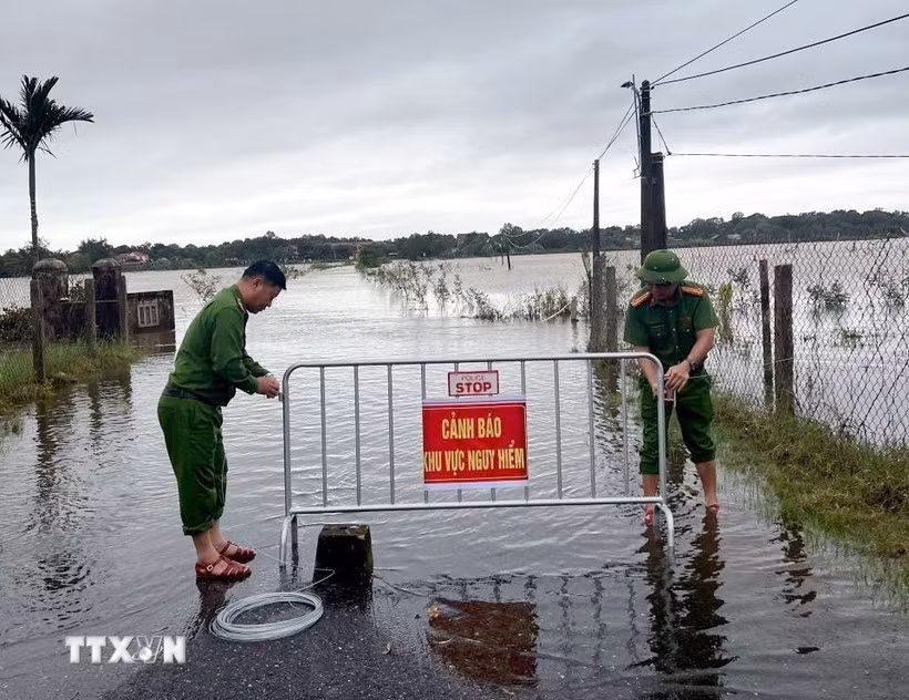 Công an xã Bến Hải (Quảng Trị) lập rào chắn, khuyến cáo người dân tuyệt đối không di chuyển qua các tuyến đường nước ngập sâu. Ảnh tư liệu: TTXVN phát