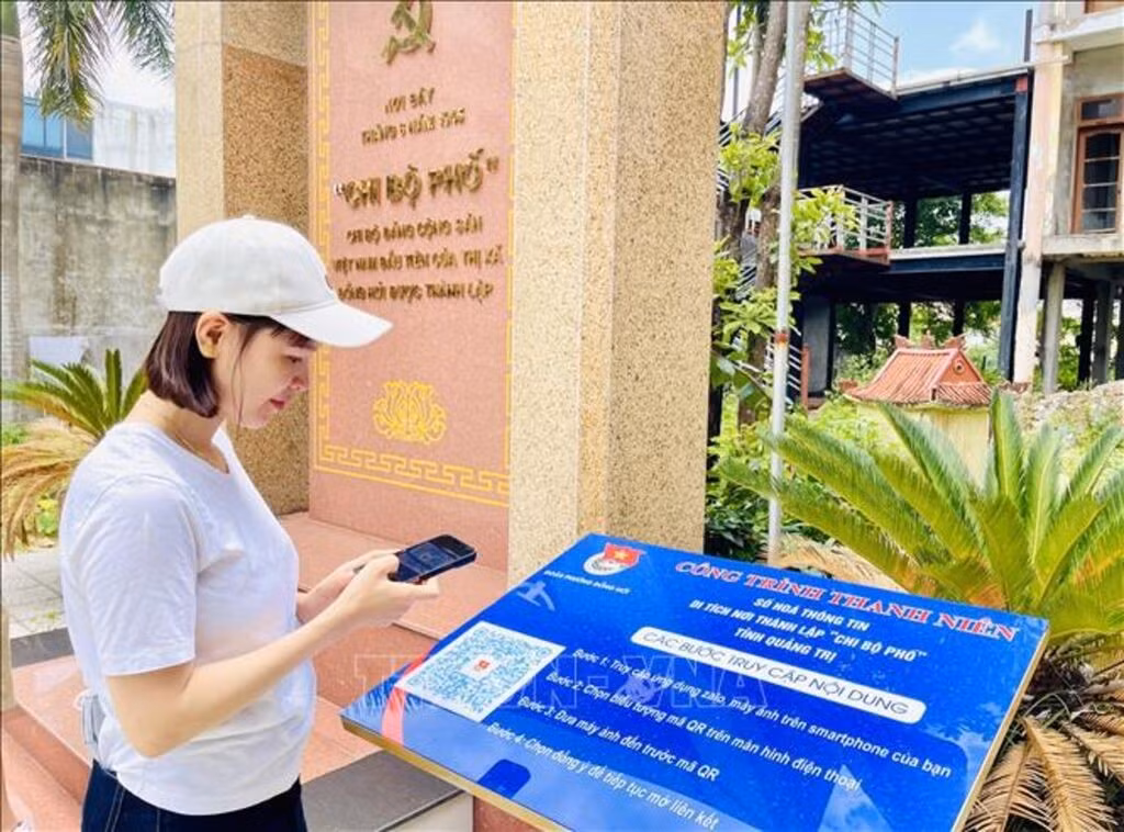 Du khách đến từ tỉnh Đắk Lắk trải nghiệm quét mã QR tại di tích nơi thành lập “Chi bộ phố” tỉnh Quảng Trị (Chi bộ Đảng Cộng sản Việt Nam đầu tiên của thị xã Đồng Hới được thành lập). Ảnh: Võ Dung/TTXVN.