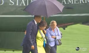 Ông Obama che ô cho nữ nhân viên