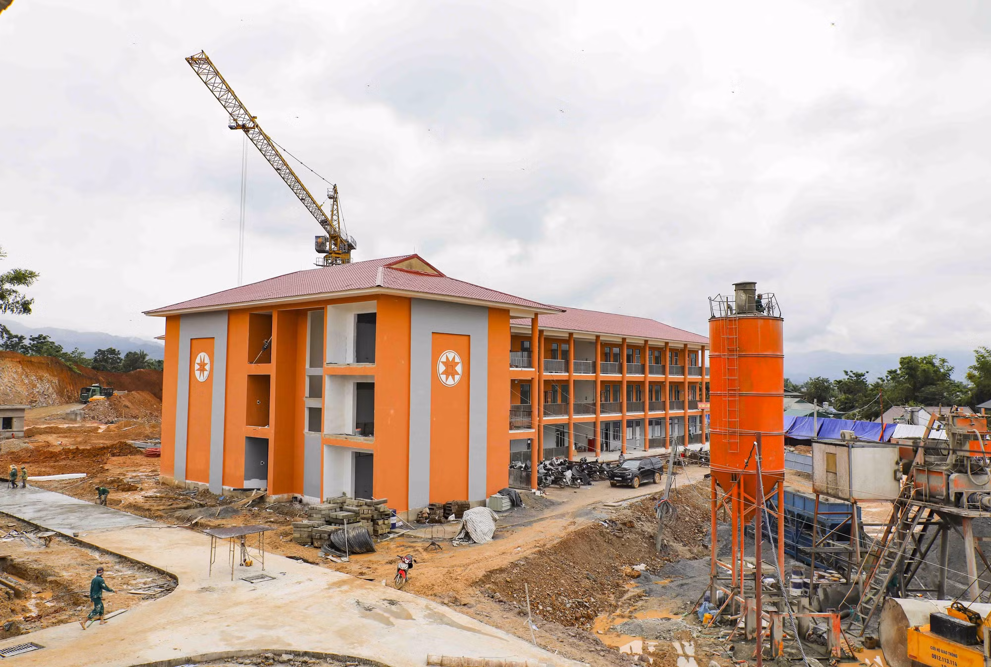 Khối nhà học kết hợp khu nội trú nổi bật giữa công trường đang được hoàn thiện những hạng mục cuối.