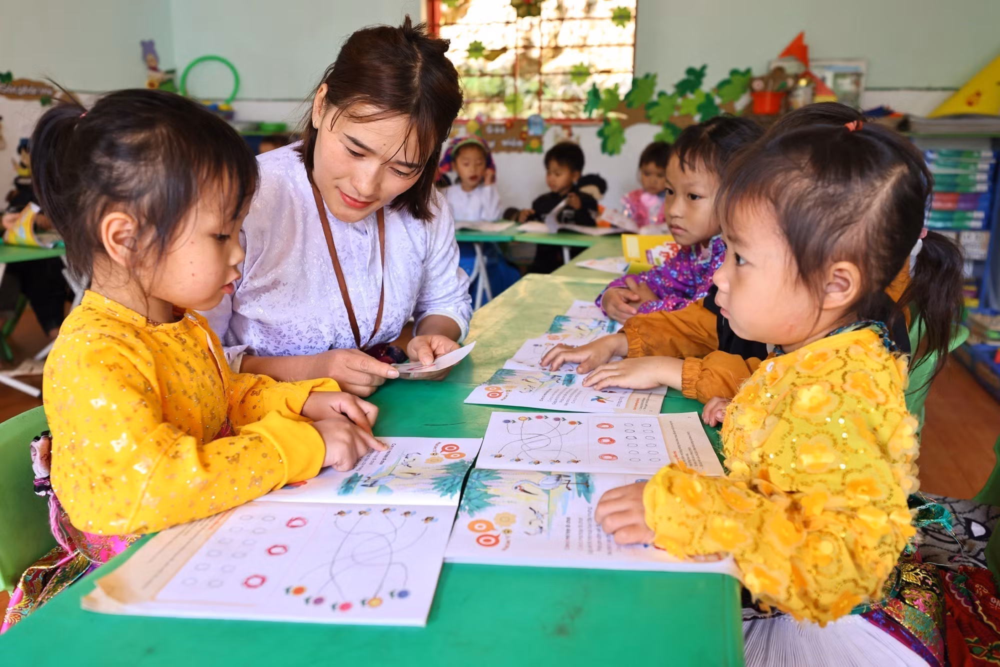 Giáo viên, đảng viên Vàng Thị Tro trong một buổi dạy lớp ghép 4 và 5 tuổi tại điểm trường Tràng Hương, xã Mèo Vạc.