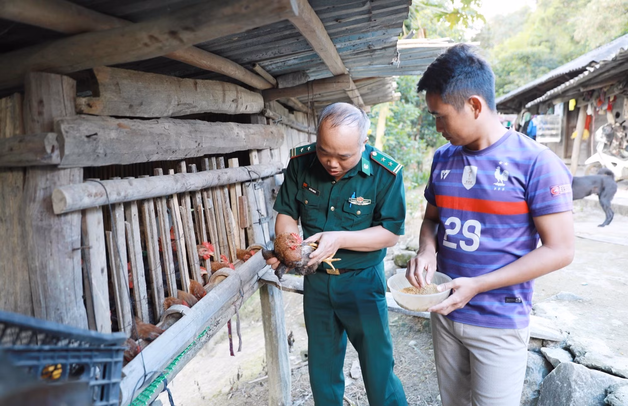 Cán bộ Đội vận động quần chúng Đồn Biên phòng Pa Tần hướng dẫn người dân cách chăm sóc đàn vật nuôi.