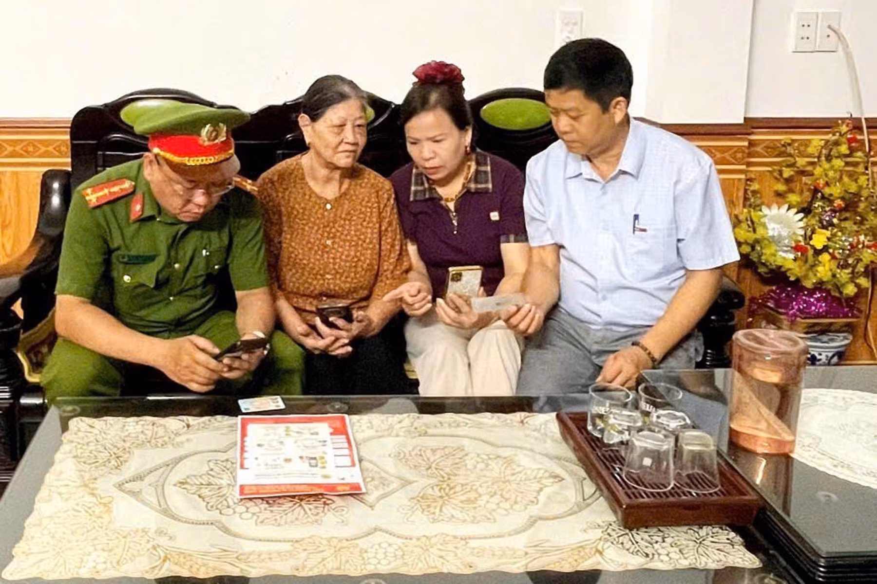 Bà Vũ Thị Thanh Thủy, Tổ trưởng tổ dân phố 1 phường Hà Giang 1 (thứ hai từ phải sang), cùng lực lượng Công an và tổ công nghệ số cộng đồng hướng dẫn người dân sử dụng các tiện ích số trên điện thoại thông minh.