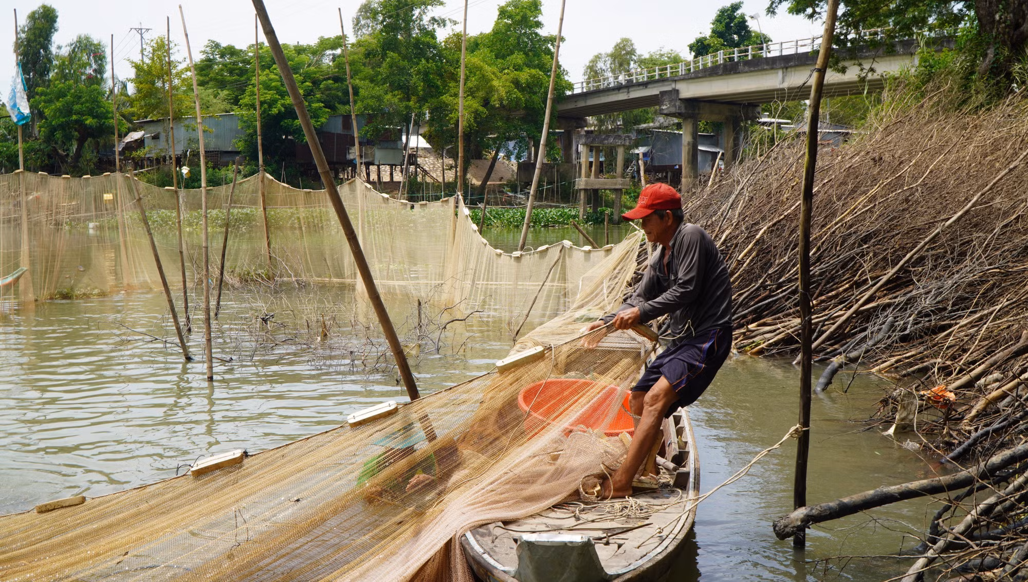 Sau khi bao lưới xung quanh đống chà, người dân kéo lưới để bắt cá.