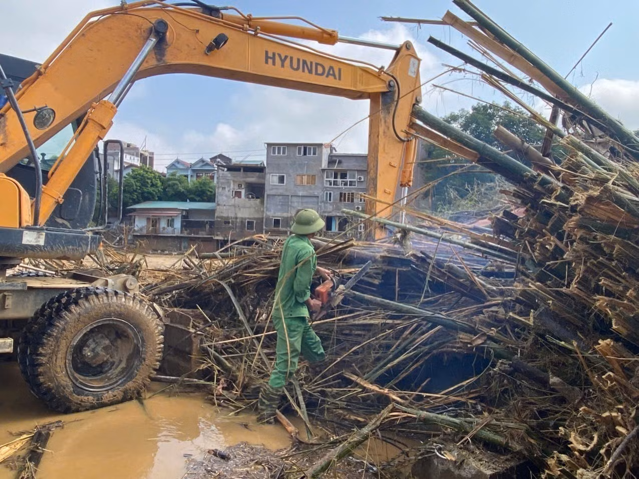 Việc tháo gỡ hàng trăm búi tre mắc tại cầu mất rất nhiều thời gian và công sức.