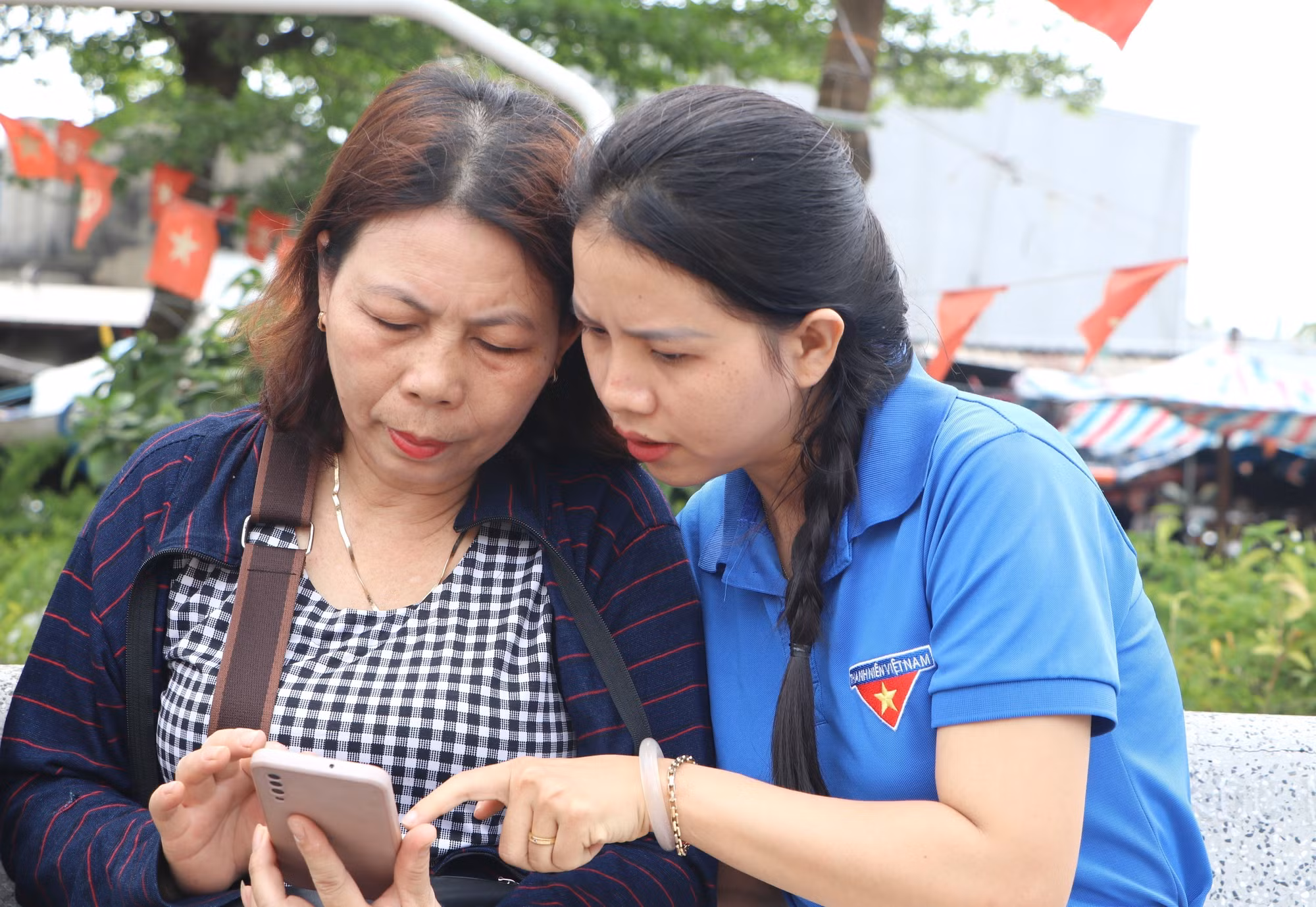 Đoàn viên thanh niên xã Bình Sơn (Quảng Ngãi) hướng dẫn người dân sử dụng các dịch vụ công trực tuyến.