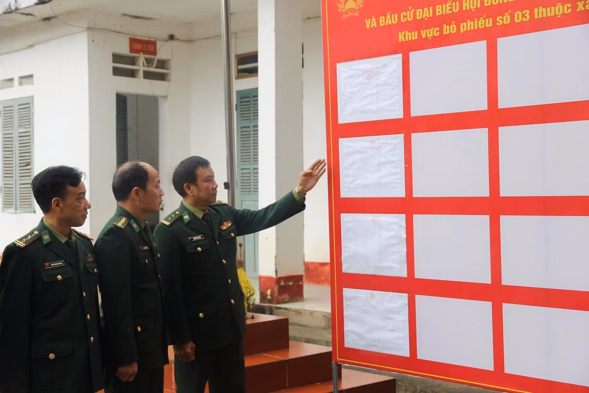 Cán bộ, chiến sỹ Đồn Biên phòng Bản Lầu kiểm tra thông tin danh sách cử tri được niêm yết tại khu vực bỏ phiếu số 3 xã Bản Lầu. Ảnh: Hương Thu/TTXVN