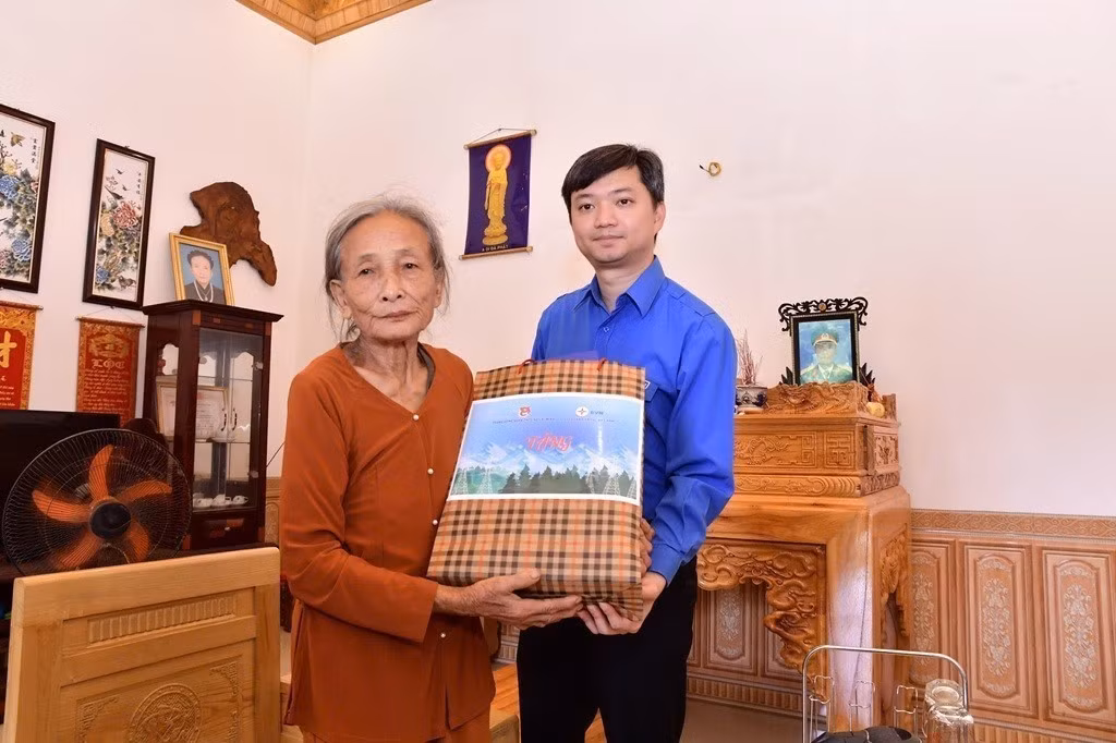 Bí thư Trung ương Đoàn, Chủ tịch Hội Sinh viên Việt Nam Nguyễn Minh Triết tặng quà cho hộ dân bị ảnh hưởng khi thi công Dự án tại tỉnh Lào Cai. Ảnh: TTXVN phát