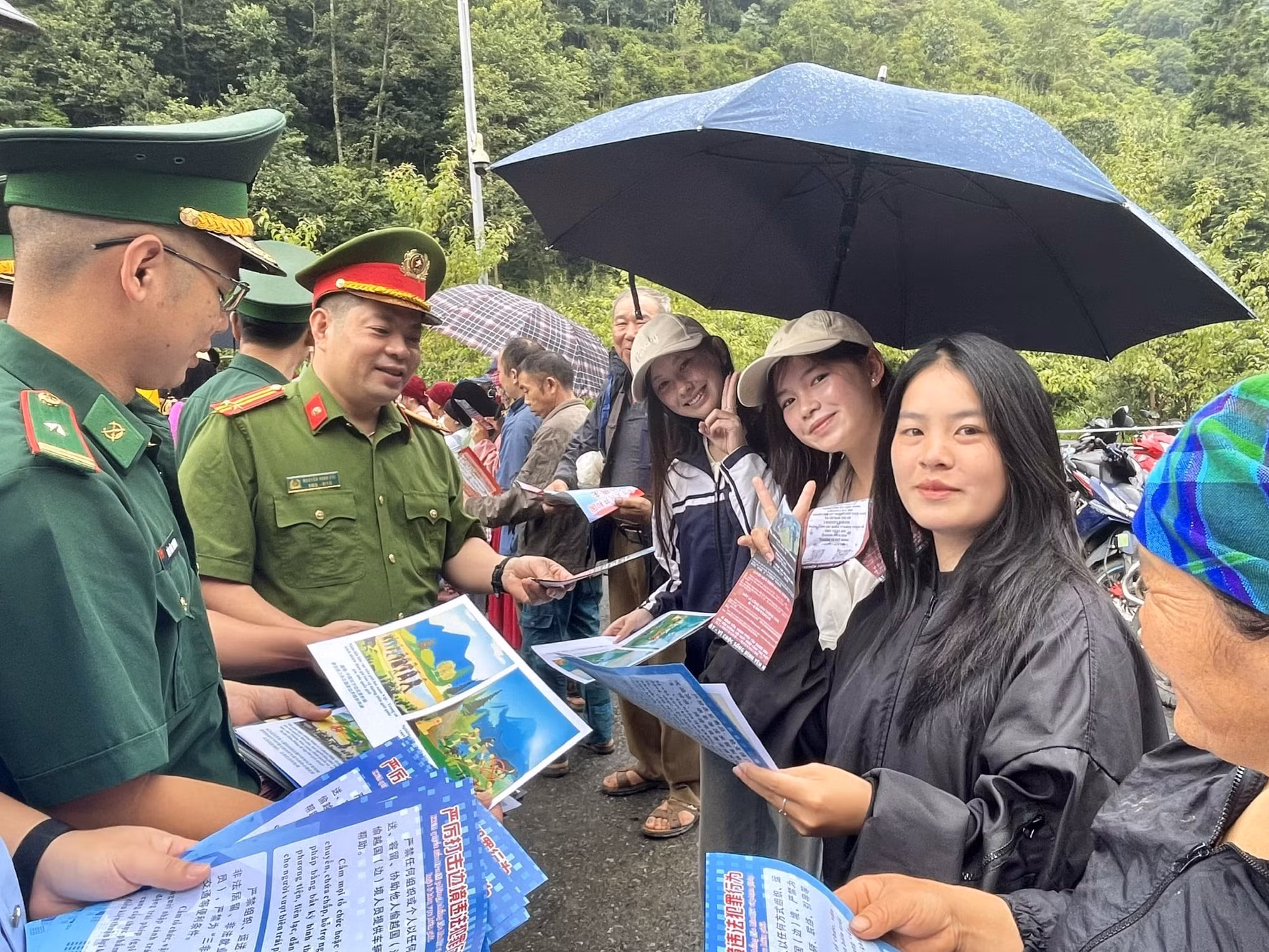 Cư dân biên giới nhận tờ rơi tuyên truyền pháp luật tại lối mở Phó Bảng - Đổng Cán.