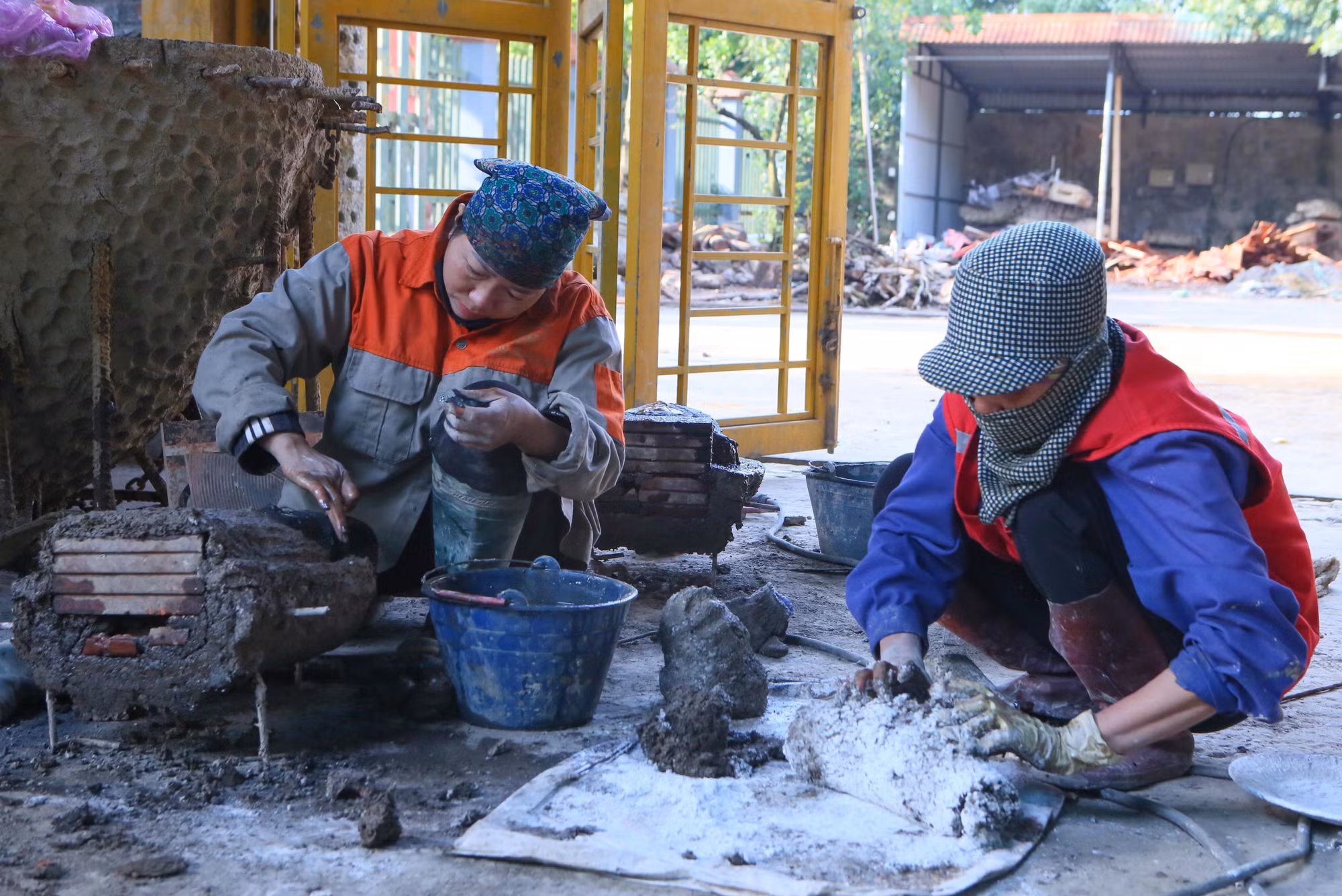 Những người thợ tại làng nghề đúc đồng Ý Yên chuẩn bị nguyên liệu để làm khuôn đúc tượng.