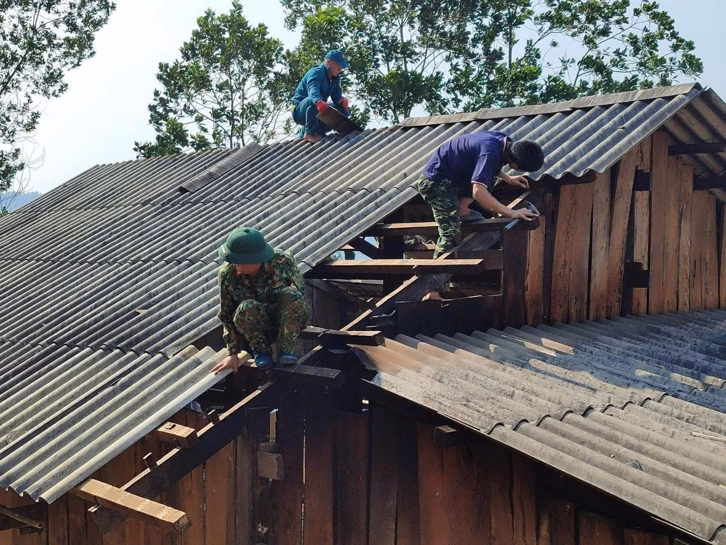 Lực lượng chức năng hỗ trợ người dân sửa chữa căn nhà bị tốc mái do dông lốc, mưa đá. Ảnh: TTXVN phát