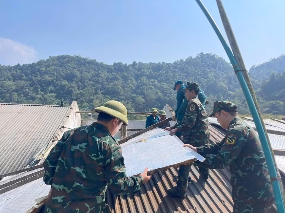 Lực lượng chức năng hỗ trợ người dân sửa chữa căn nhà bị tốc mái do dông lốc, mưa đá. Ảnh: TTXVN phát