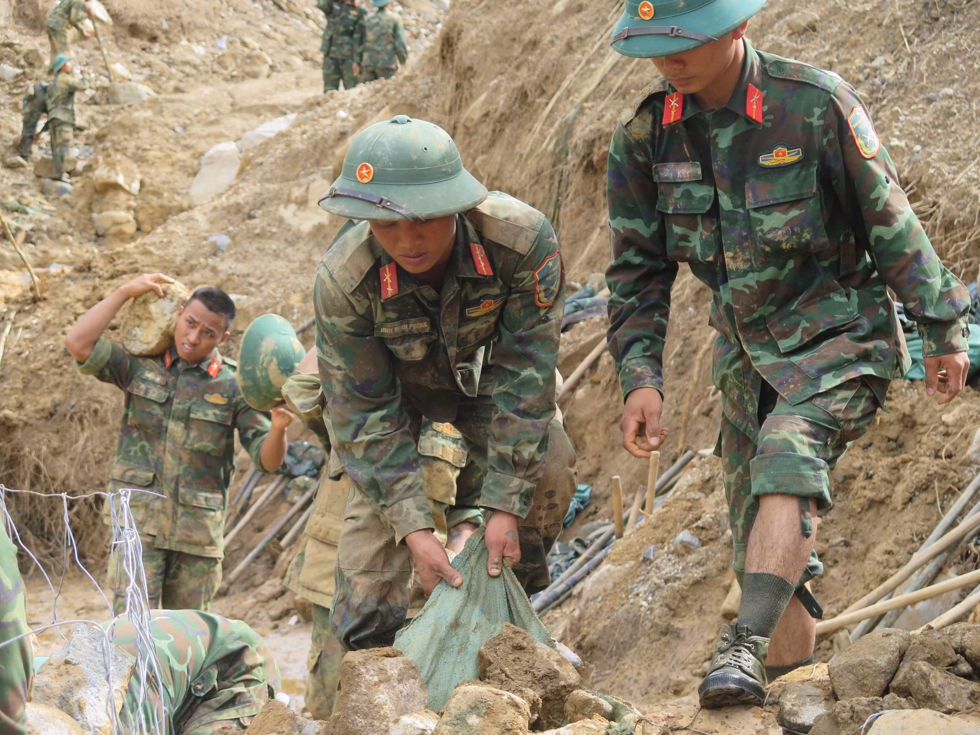 Cán bộ, chiến sĩ Quân đoàn 34 triển khai công tác mở đường vào các thôn bị cô lập do mưa lũ ở xã Ngọc Linh.