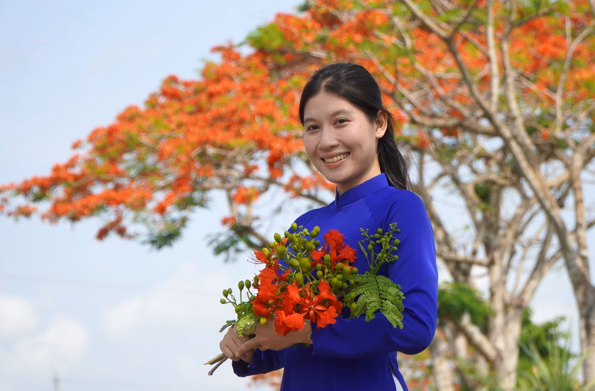 Bạn trẻ chụp ảnh với hàng phượng Lấp Vò.