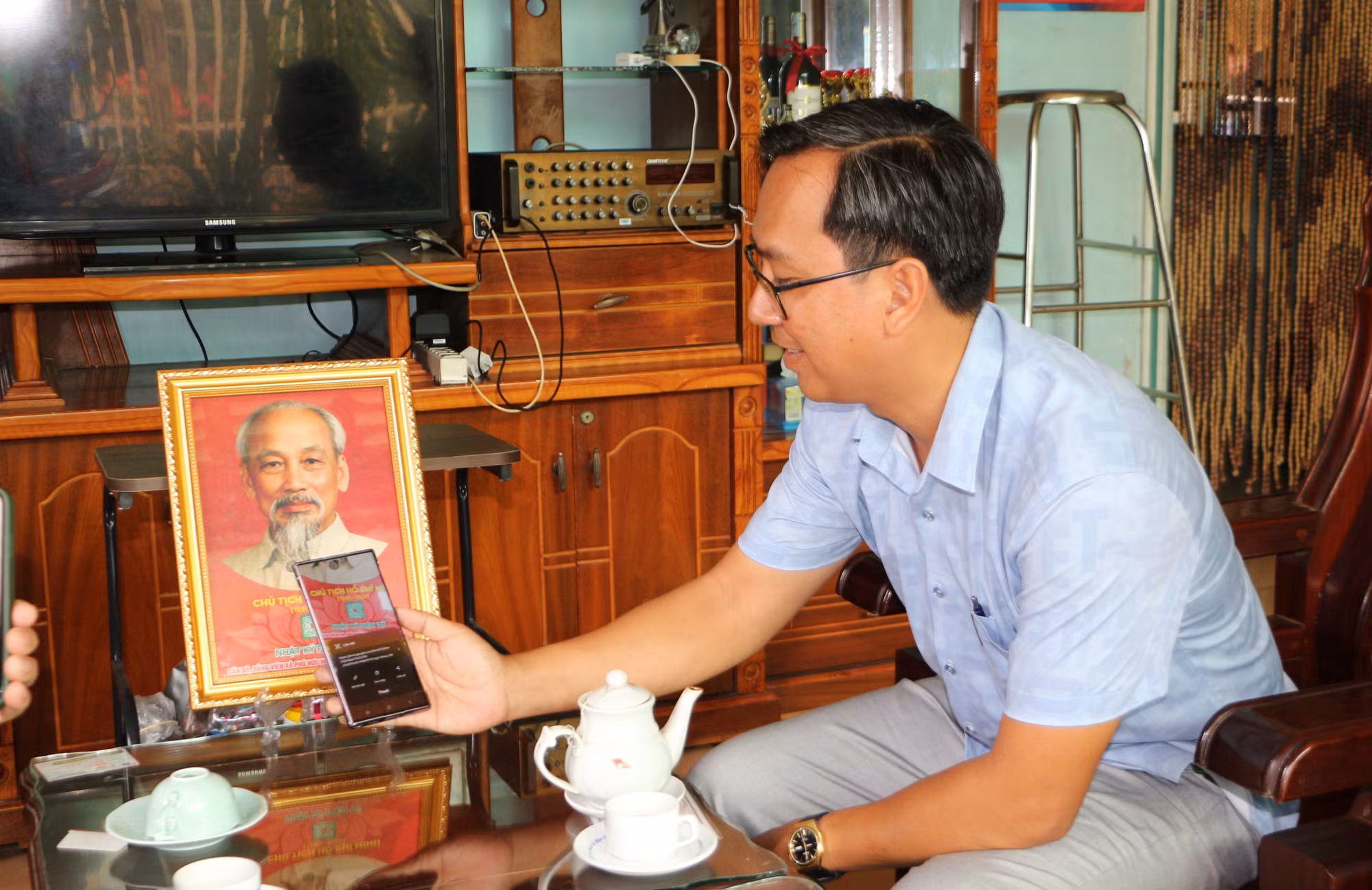 Đảng viên quét mã QR Code in dưới ảnh Bác Hồ để tìm hiểu những thông tin, câu chuyện kể về Bác.