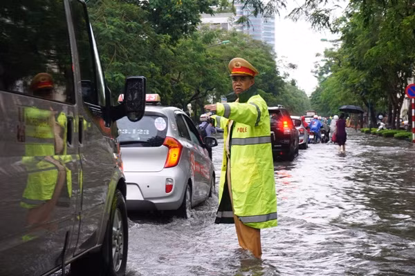 Bóng 'áo vàng' dầm mưa, lội nước phân luồng giao thông trong mưa ngập ảnh 1