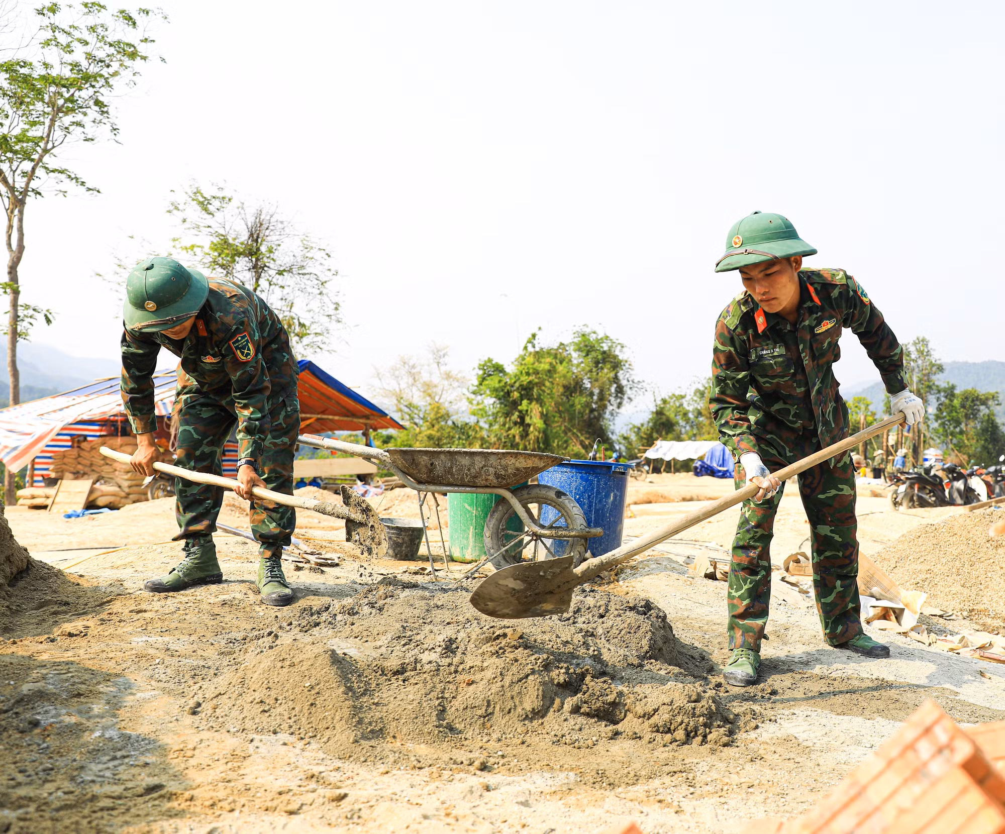 Cán bộ, chiến sĩ thuộc Trung đoàn 741 (Bộ Chỉ huy Quân sự tỉnh Điện Biên) trộn vật liệu để xây dựng nhà cho các hộ dân ở bản Mường Pồn 2.