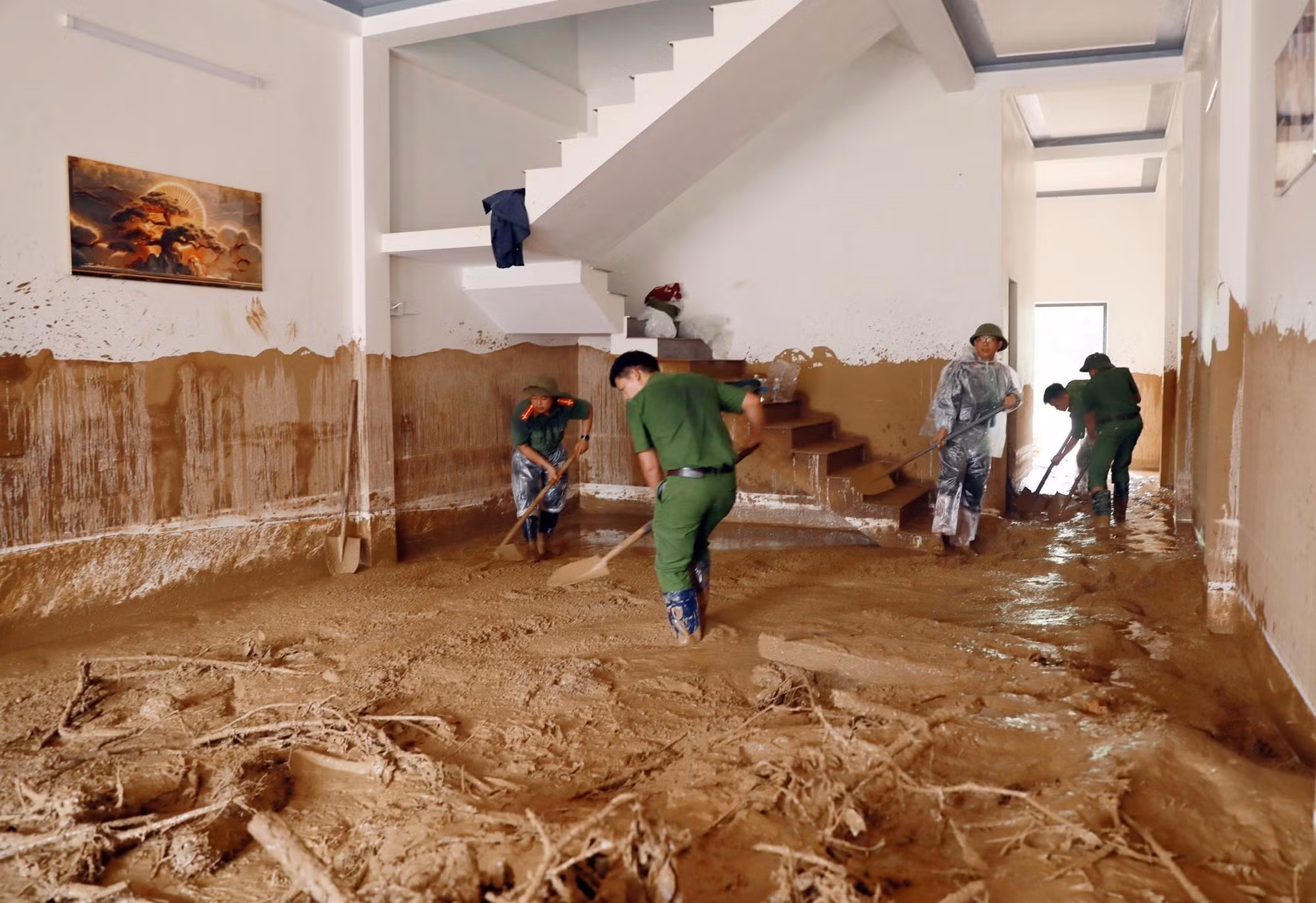 Nước lũ rút đến đâu là có lực lượng vũ trang hỗ trợ người dân dọn dẹp nhà cửa, vệ sinh môi trường để sớm ổn định cuộc sống tại xã Mường Than. Ảnh: Quý Trung/TTXVN