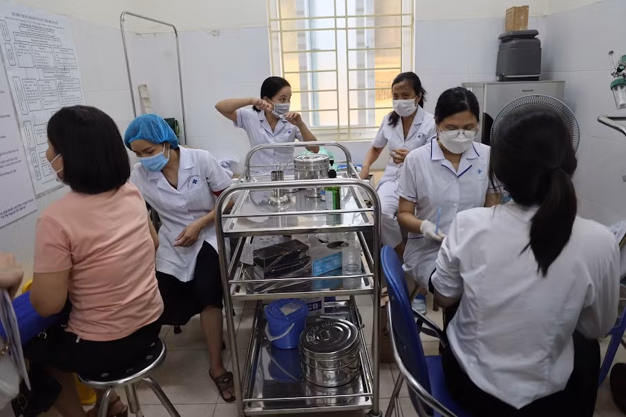 Người dân xếp hàng đi tiêm mũi nhắc lại vaccine phòng COVID-19