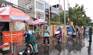 Người dân đội mưa đi tiếp tế tại phường Chương Dương do bị cách ly thêm 14 ngày