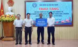 Tổng Giám đốc BHXH Việt Nam trao tặng đại diện người dân tại Quảng Bình sổ BHXH, thẻ BHYT.