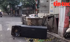 Rác thải là cả chiếc giường gội đầu bị vứt chỏng chơ giữa đường tại điểm tập kết xe rác trên phố Cầu Gỗ (quận Hoàn Kiếm) vào sáng sớm.