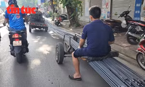 Hình ảnh xe 3 bánh tự chế kéo theo xe 3 gác chở sắt xây dựng dài nguy hiểm trên phố Đội Cấn (quận Ba Đình).