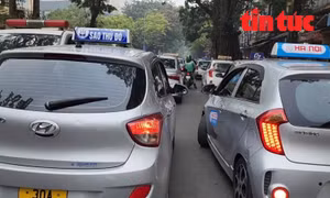 Cảnh cả 2 hàng taxi đỗ song song trên phố Phủ Doãn trước cổng Bệnh viện Việt Đức, gây ùn tắc giao thông.