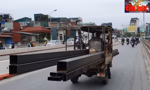 Xe 3 bánh thương binh chở sắt hộp quá khổ, quá tải, không che chắn trên đường dẫn cầu Chương Dương, gây nguy hiểm cho người đi đường.