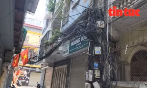 Nhức mắt búi "rác trời" bao gồm các loại cáp điện lực, cáp viễn thông cũ mới bu kín cột điện trong ngõ 88 phố Thái Hà.  
