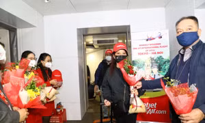Lãnh đạo Cục Hàng không Việt Nam tặng hoa cho hành khách trên chuyến bay.