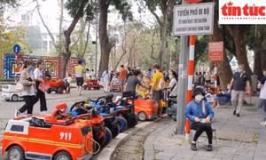 Chủ hộ kinh doanh xe điện scooter ngồi thu tiền cho thuê xe tại chỗ.