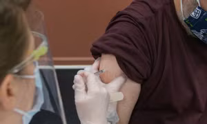 Người đàn ông đeo tay giả đi tiêm vaccine COVID-19 để lấy giấy chứng nhận