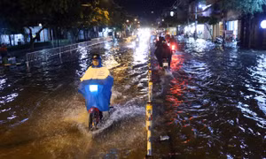 Người dân TP Hồ Chí Minh bì bõm về nhà sau cơn mưa lớn