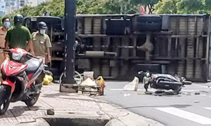 Xe tải chở gạo bị lật khi tránh xe máy băng qua đường