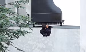 Nghệ sĩ treo ngược người chơi piano từ độ cao 40 m