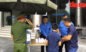 Thanh niên TTXVN hỗ trợ thông tin và nước uống cho người dân đến viếng Tổng Bí thư 