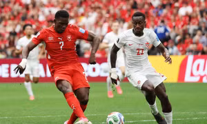 Tiền đạo Breel Embolo (trái) của Thuỵ Sĩ dứt điểm nhưng cú sút chưa đủ hiểm để đánh bại thủ môn Canada. Ảnh: AFP/TTXVN (Ảnh không cho phép bên thứ ba khai thác, chia sẻ lại)