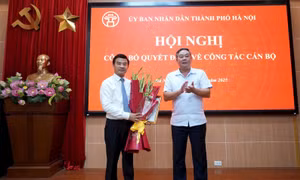 Phó Chủ tịch Thường trực UBND thành phố Hà Nội Lê Hồng Sơn trao quyết định, tặng hoa chúc mừng ông Nguyễn Xuân Lưỡng.