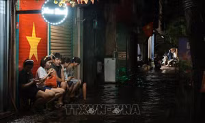 Hà Nội: Người dân ngồi trú mưa, chờ nước ngập rút trên phố Nguyễn Du