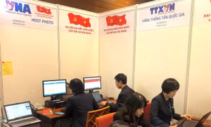Các phóng viên tác nghiệp tại Trung tâm báo chí trong ngày đầu làm việc của Đại hội Đảng XIII