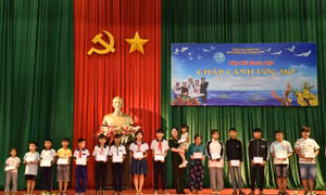 Đại diện gia đình cùng các cháu mồ côi cha, mẹ tại địa phương nhận quà từ chương trình “Phụ nữ Quân đội chắp cánh ước mơ”