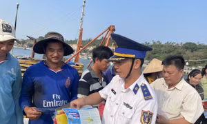 Cán bộ BTL Vùng Cảnh sát biển 4 tuyên truyền, phát tờ rơi trực tiếp cho ngư dân tại cảng cá