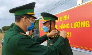 Đại tá Huỳnh Văn Đông - Bí thư Đảng ủy, Chính ủy Bộ đội Biên phòng tỉnh Kiên Giang gắn quân hàm cho các sĩ quan tại chốt kiểm dịch COVID-19. 